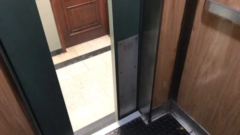 Going up alone in an dirty old elevator with windows in the door. Arriving Stock Footage 97630263