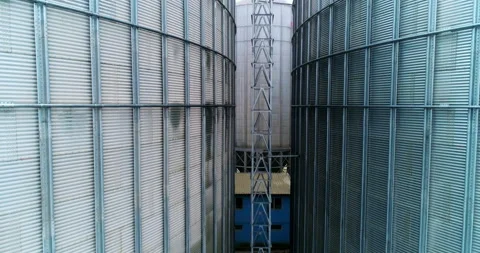 Going up between two metal elevator tanks to the tops.  Stock Footage 169356548