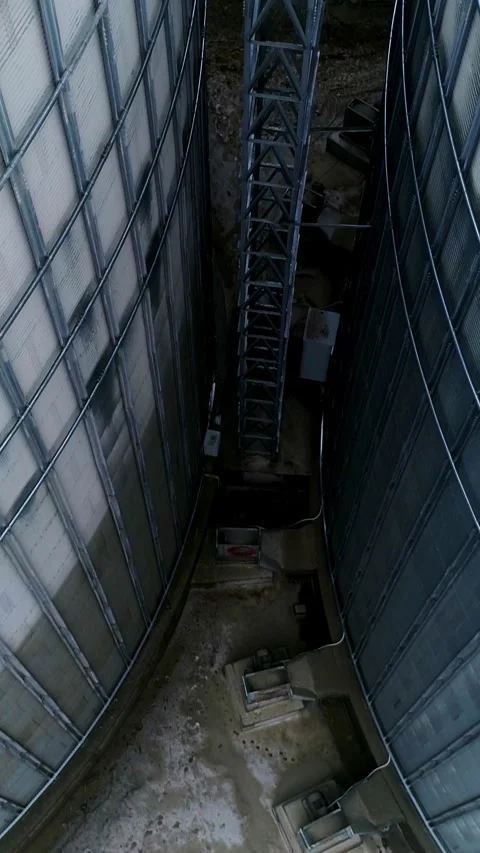 Going down among two huge metal granary tanks.  Stock Footage 280507467