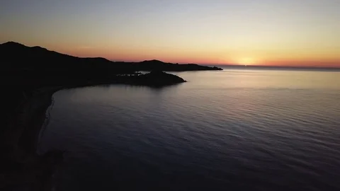 Going down with the drone in the sunrise of sardinia sea Stock Footage 80605967