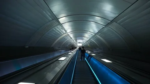 Going down to the metro station by escalators through the illuminated tunnel. Stock Footage 129085958
