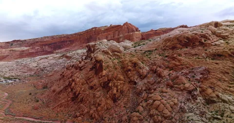 Going down over the orange rocky hills with little greenery. Stock Footage 212114786