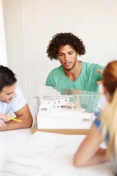Going over the model. A group of architects discussing a building model during a Fotos de archivo