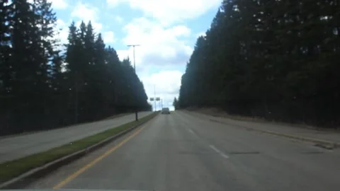 Going up the ramp between pines on a highway Stock Footage 146617986