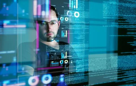 Going through endless data streams. a young computer programmer looking through Stock-Fotos