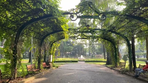 Going through green park arch in Tao Dan Park, Ho Chi Minh City Stock Footage 219370434