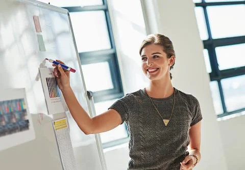 Going through her creative process. a designer brainstorming on a whiteboard in Foto stock
