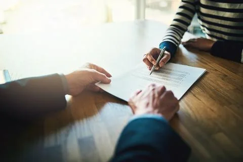 Going through the terms of their contract. Closeup shot of two unrecognizable Stock Photos