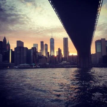 Going under the Brooklyn Bridge in a ferry, view of lower Manhattan skyline Stock Photos