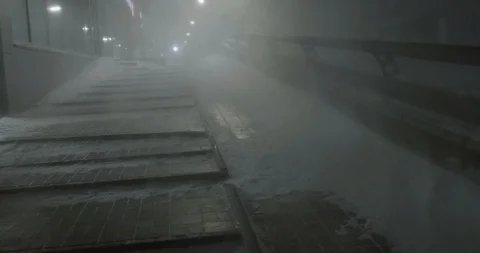 Going upstairs through the blizzard in a night cityscape in winter Stock Footage 87079569
