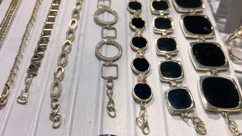 Gold and Black Stone Bracelets Display on White Jewelry Store Showcase | Luxury Stock Footage 333656320