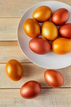 Gold and bronze Easter eggs on a wooden background. Stock Photos
