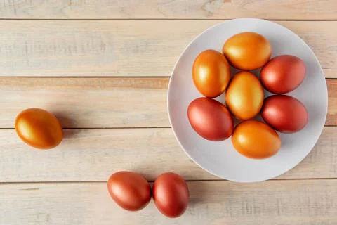 Gold and bronze Easter eggs on a wooden background. Stock Photos