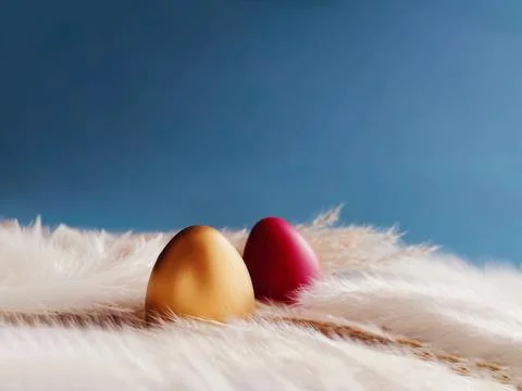 Gold and red Easter eggs nesting on soft feathers, celebrating springtime h.. Stock Photos