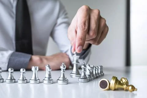 Gold and silver chess with player, Hands of businessman moving chess figure i Stock Photos