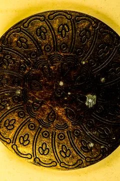 A gold and silver object with a pattern of leaves and flowers Stock Photos