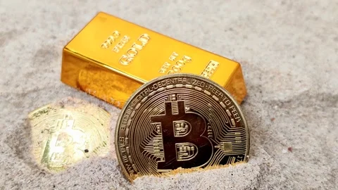 Gold bars and Bitcoin (BTC) on a sand background Video stock 325015557
