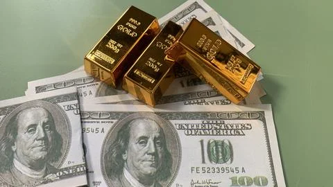 Gold bars placed on multiple US hundred dollar bills, Stock Photos
