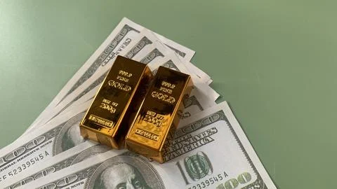 Gold bars placed on multiple US hundred dollar bills, Stock Photos