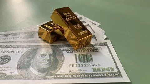 Gold bars placed on multiple US hundred dollar bills, Stock Photos