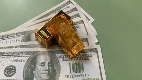 Gold bars placed on multiple US hundred dollar bills, Stock Photos