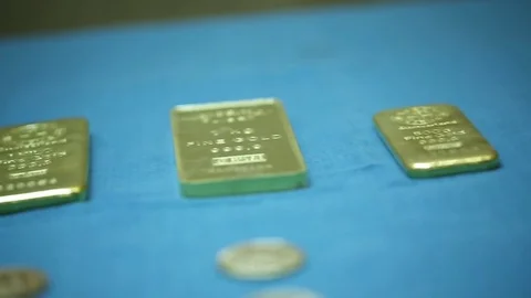 Gold biscuits of various sizes arranged on a table Stock Footage 77444034