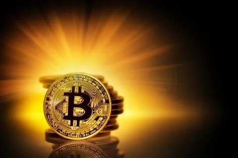 Gold bitcoin and a stack of coins in yellow rays Stock Photos