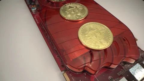 Gold BITCOIN BTC. Two coins rotate clockwise on red videocard. white background Stock Footage 129613716