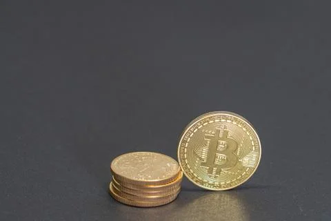 A gold Bitcoin coin is equivalent to a stack of gold dollars worth 10000 doll Foto stock