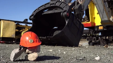 Gold bitcoin on a protective helmet next to the bucket of a mining excavator. Stock Footage 89309278