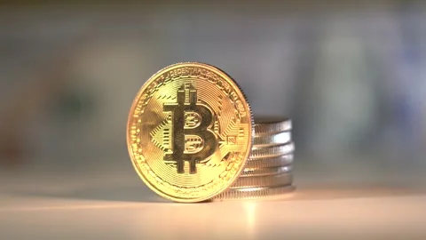 Gold Bitcoin rotate on the table with many other cryptocoins. Golden reflection Stock Footage 142503936