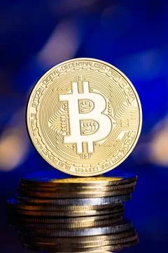 A Gold bitcoin on a stack of coins. Stock Photos