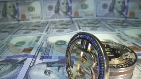 Gold Bitcoin with violet reflection on coin and many american dollars on the Video stock 141919343