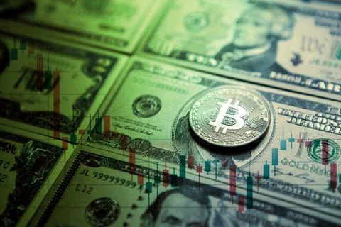 Gold bitcoins on a stack of coins with chart of growing and falling valuance of Stock Photos