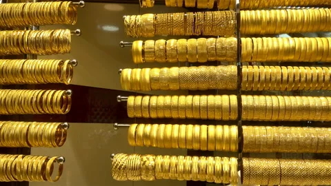Gold bracelets hang on horizontal racks in 4K. Stock Footage 127713723
