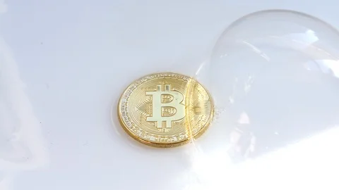 Gold BTC bitcoin cryptocurrency coin with soap bubble passing over them, Stock Footage 85709649