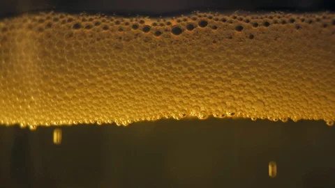 Gold bubbles floating on a liquid cider Stock Footage 89310379