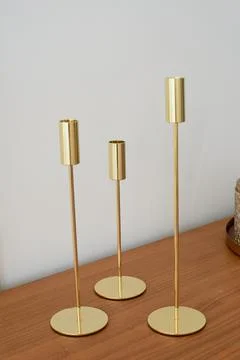 Gold candlesticks of different heights without candles. Minimalist style Stock Photos