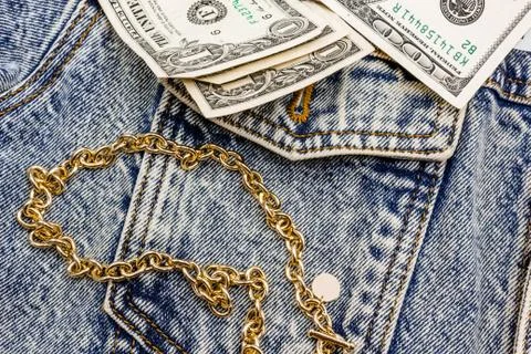 Gold chain and American dollars on a denim jacket. casual wear. Bijuteria Stock Photos