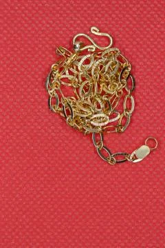 Gold chain on red background Stock Photos