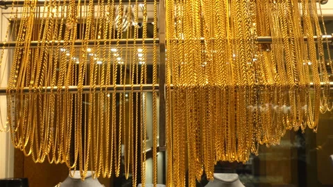 Gold chains hang on a stand in 4K Stock Footage 125659242