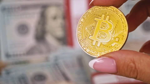 Gold Coin of Bitcoin on the Background of One Hundred Dollar Bills Stock Footage 212947529