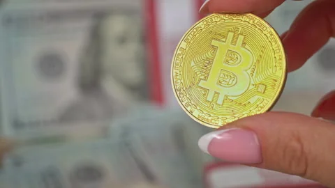 Gold Coin of Bitcoin on the Background of One Hundred Dollar Bills Stock Footage 213399608