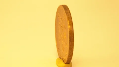 A Gold Coin With A Value Is Rotating Around The Screen Of A Yellow Background Stock Footage 129483173