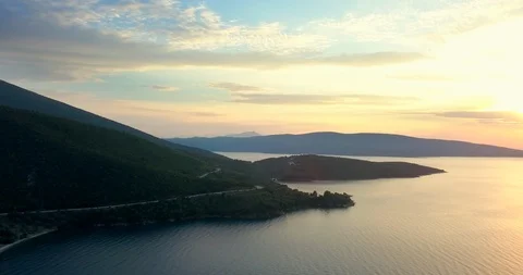 Gold colored sunset over hilly coastline Stock Footage 107962134