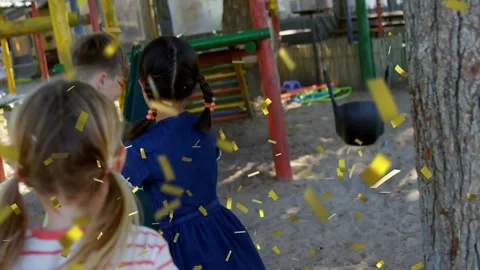 Gold confetti falling, three kids circling tree clockwise, running past slide, Stock Footage 331161115