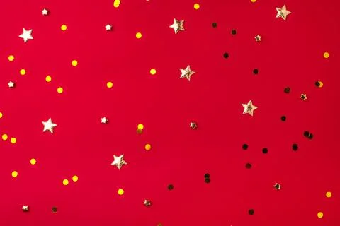 Gold confetti on red background. Stock Photos