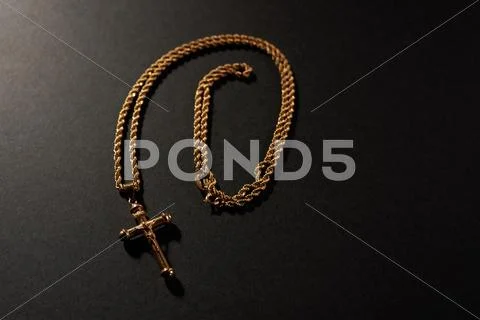 Gold cross on a chain on a black background Stock Photos