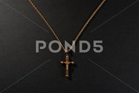 Gold cross on a chain on a black background Stock Photos