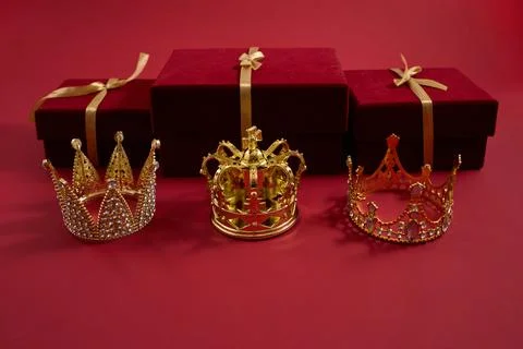 Gold crowns with gift boxes symbolizing luxury and reward. Three golden crowns Stock-Fotos